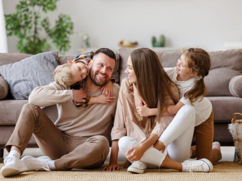 Young, happy family playing on the floor in their Long Island home