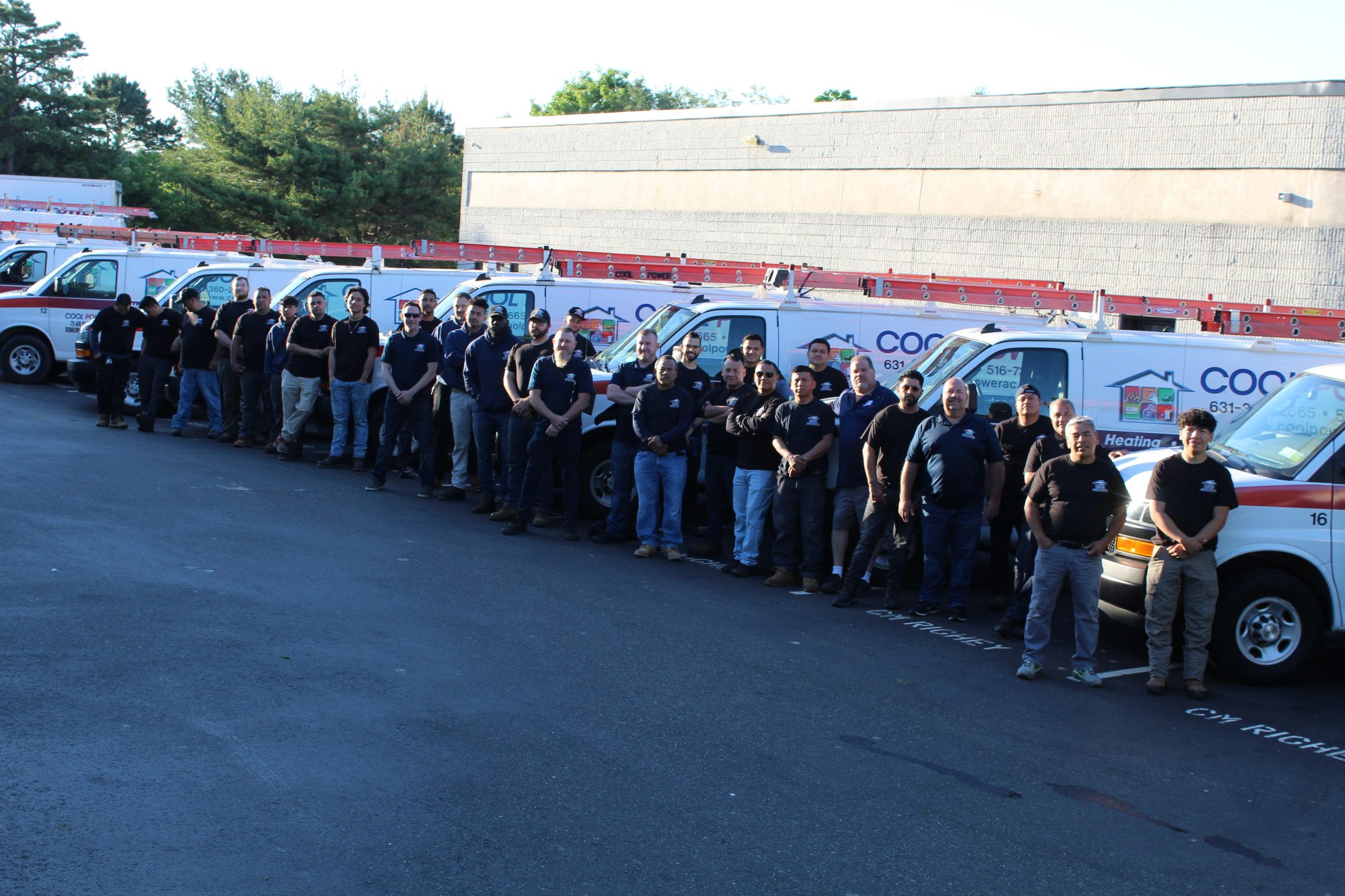 Employees in front of fleet of cars